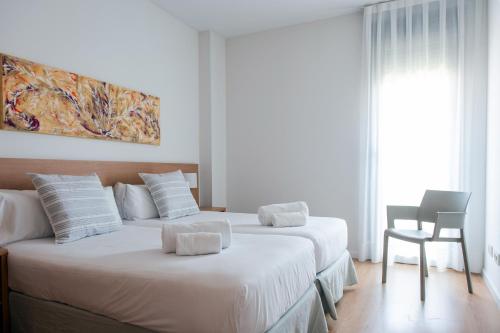 略夫雷加特河畔奥斯皮塔莱特奥拉公园菲拉BCN公寓的配有白色墙壁的酒店客房内的两张床