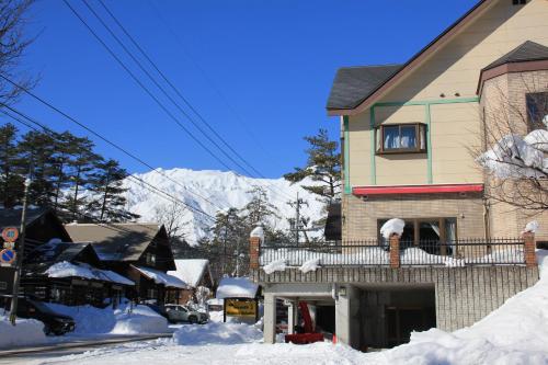 白马村白马第七天堂酒店的一座雪覆盖的房子,背景是一座山