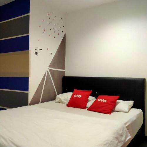莎阿南1st Inn Hotel Glenmarie的房间里的床上有两个红色枕头