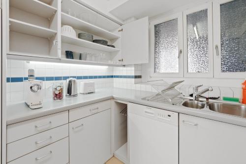 苏黎世Spacious Central Apartments HOTING的白色的厨房配有白色橱柜和水槽