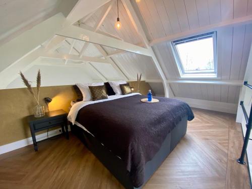PeinsKerkje van Peins的阁楼上的卧室配有一张大床