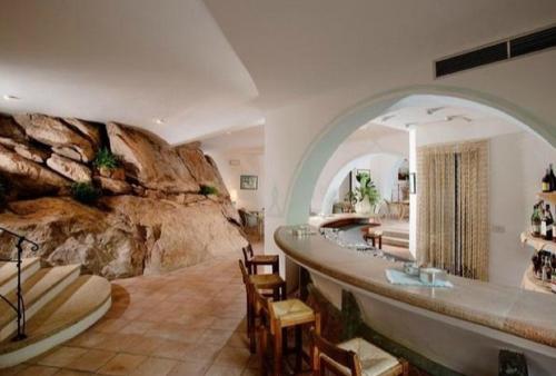 阿比亚多利green park cala di volpe的带岩石墙的客房和带冲浪板的浴室