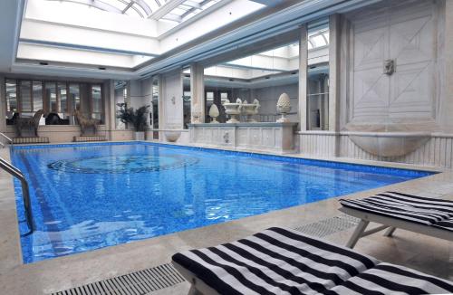 北京北京中航泊悦酒店 的一座大型游泳池,位于一座拥有大型天花板的建筑内