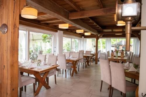 迪尔门泰克斯密尔酒店-餐厅的餐厅设有木桌、椅子和窗户。