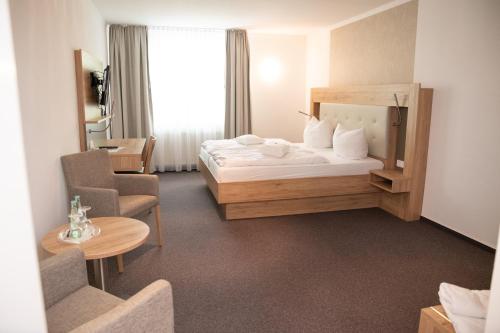 迪尔门泰克斯密尔酒店-餐厅的配有一张床和一把椅子的酒店客房