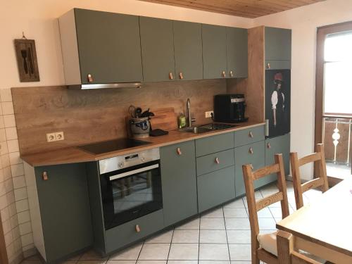 沃尔法赫Morgethof的厨房配有绿色橱柜、水槽和炉灶。