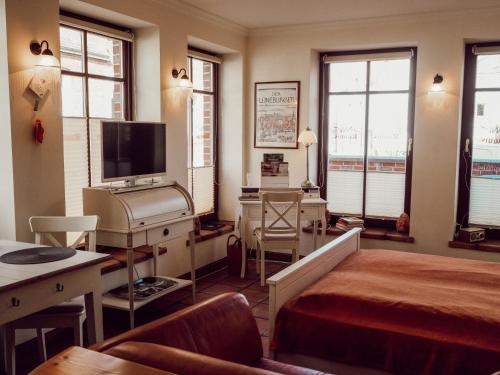 吕讷堡Backsteinparadies的一间卧室配有一张床、一张书桌和一台电视。