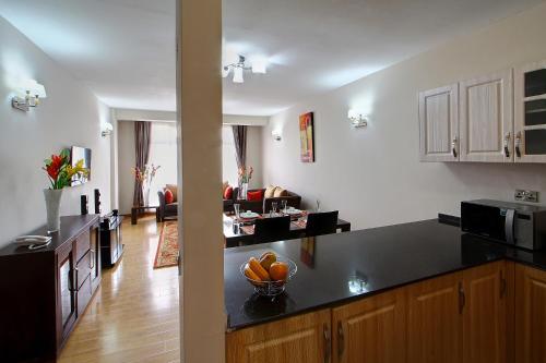 内罗毕飞纳斯花园公寓酒店的一个带台面的厨房和一间客厅