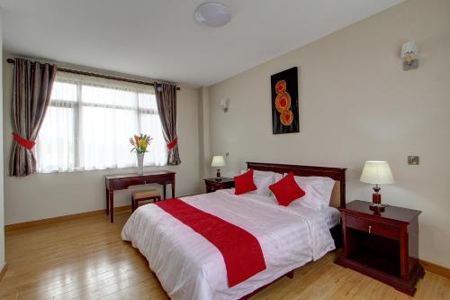 内罗毕飞纳斯花园公寓酒店的一间卧室设有床、两张桌子和一扇窗户