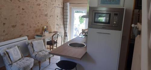 Moisenay玛哈拉尼斯住宿加早餐旅馆的厨房配有水槽和冰箱上的微波炉