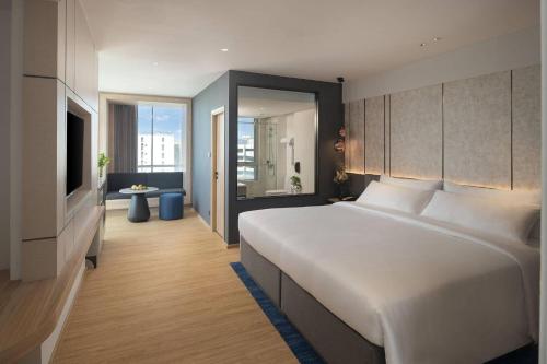 曼谷Miracle Grand Convention Hotel的卧室配有一张白色大床和电视。