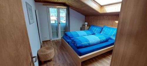 维尔德斯韦尔Chalet Sunnmätteli的一间卧室配有一张带蓝色枕头的床和一扇窗户。