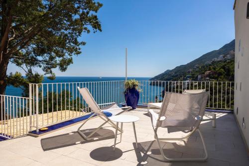 维耶特里Decori Suites Amalfi Coast的阳台配有椅子,享有海景。