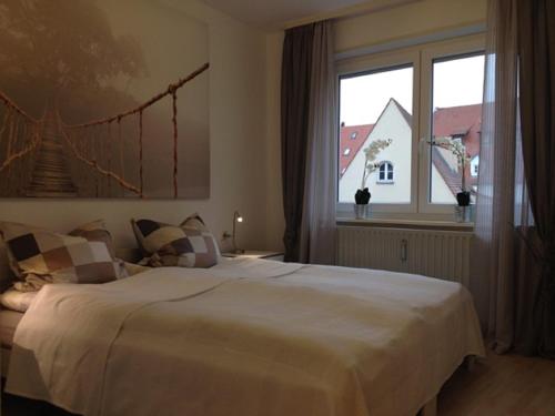 奥格斯堡斯坦恩豪瑟之家公寓的卧室设有一张白色大床和一扇窗户。