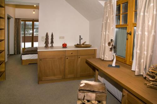 施瓦岑贝格波蒂勒高山酒店的客房设有带一张床和一张书桌的卧室。