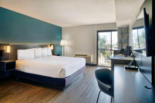 朗代尔Studio 6 Suites Lawndale, CA South Bay的配有一张床、一张书桌和一扇窗户的酒店客房