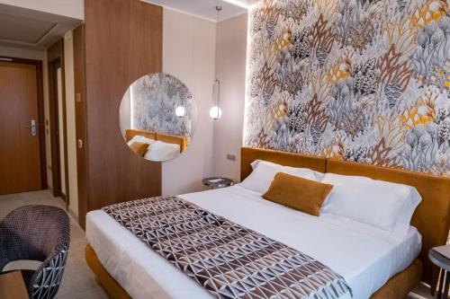卡斯特罗齐耶罗利欧拉酒店的一间卧室设有一张带花卉墙壁的大床