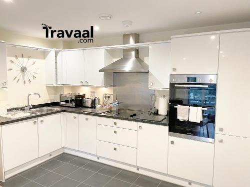 法恩伯勒Travaal.©om - 2 Bed Serviced Apartment Farnborough的白色的厨房配有白色橱柜和电器