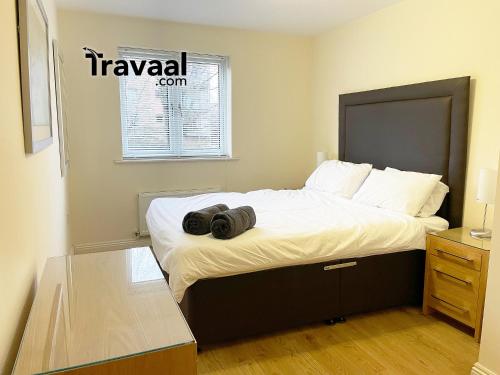 法恩伯勒Travaal.©om - 2 Bed Serviced Apartment Farnborough的一间卧室配有一张大床,上面有两个黑色的东西