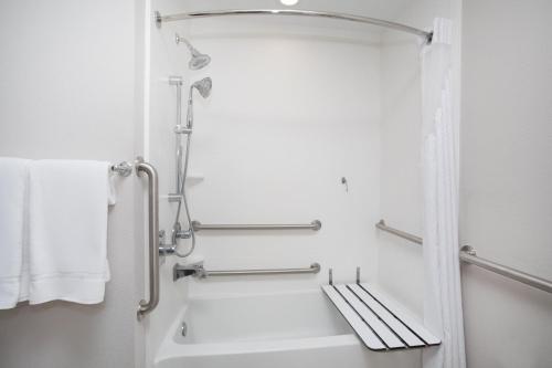 斯莱德尔Holiday Inn Express Slidell, an IHG Hotel的带淋浴和白色浴缸的浴室