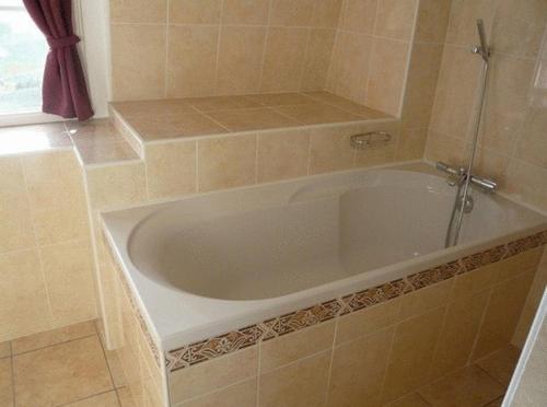 普卢加斯努卡梅林酒店的瓷砖浴室设有白色浴缸。