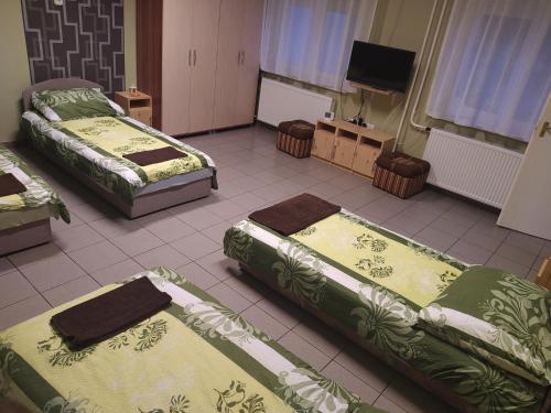 绍尔特沃德凯特Pingpong Apartman的客房设有三张床和一台平面电视。