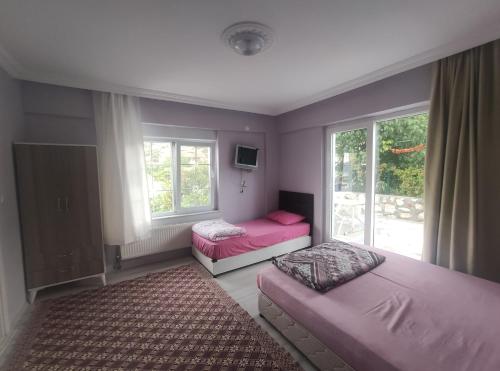 YeşilovaKaplan Apart - Pansiyon的一间卧室设有两张床和窗户。