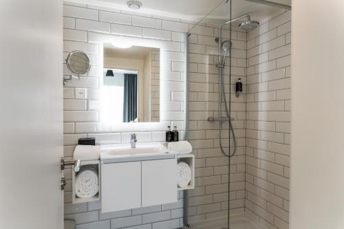 日内瓦Appart'City Collection Genève Aéroport - Vernier的白色的浴室设有水槽和镜子