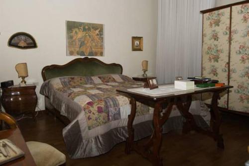 帕多瓦帕拉佐阿尔提那特 - 诺特迪皮亚诺公寓的一间卧室配有一张床、一张桌子和一张书桌