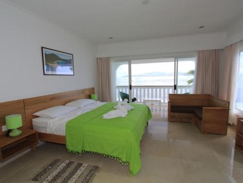 拉迪格岛法国海滨玛丽公寓酒店的一间卧室配有一张带绿毯的床