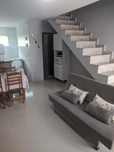 卡波布里奥Duplex Cabo frio I的带沙发和楼梯的客厅