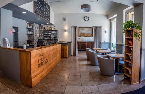 布拉格Hotel Brixen的餐厅设有酒吧和桌椅