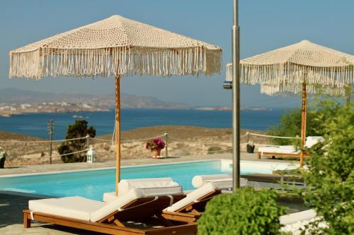 帕罗奇亚蓝海湾和里斯酒店的一个带两把遮阳伞和两把躺椅的游泳池