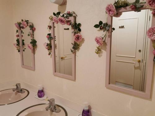 KutsukakeKitasaku District - Hotel - Vacation STAY 89259的浴室设有2个水槽和2面带鲜花的镜子