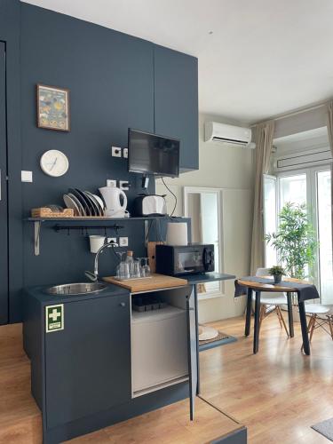 波尔图Impar Studios的厨房设有蓝色的墙壁、一个柜台和桌子