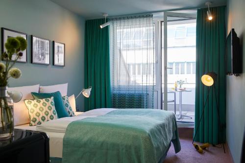慕尼黑Hotel Metropol by Maier Privathotels的一间卧室配有一张带绿色窗帘的床和窗户。