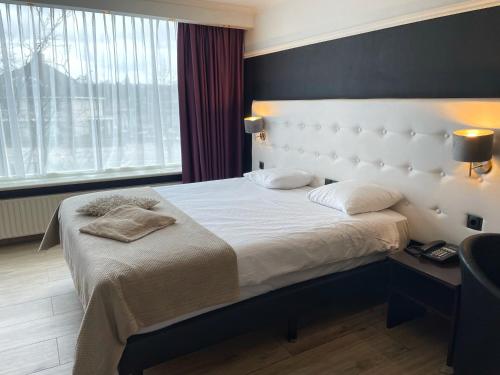 莫伦霍克莫伦-奈梅亨凡德瓦克酒店的一间卧室配有一张带白色床头板的大床