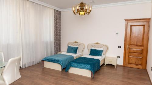 巴库Utopia Hotel Baku的一间带两张床和吊灯的客厅