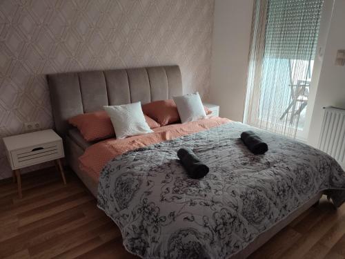 萨尔瓦尔Dévai-LUX Apartman Sárvár的一间卧室配有一张床,上面有两张黑色拖鞋