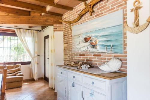 奥罗塞伊villa con immenso giardino的厨房设有砖墙和柜台。