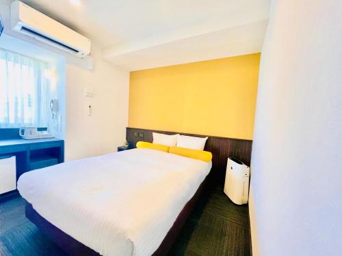 大阪日本桥水晶酒店的卧室配有白色的床和黄色的墙壁
