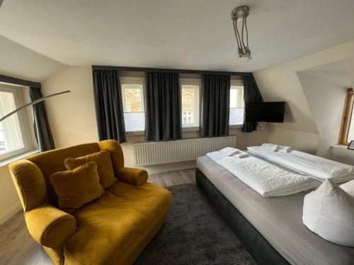 吕贝克菲林豪斯维图切特旅馆的一间卧室配有一张床、一张沙发和窗户。