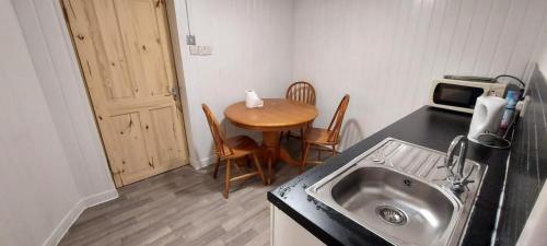 罗瑟勒姆Lovely 3-Bed Apartment in Parkgate Rotherham的厨房配有水槽和桌椅