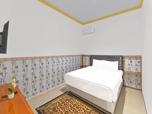 吉利马努克OYO 91192 Homestay Antara的一间小卧室,配有白色的床和一张桌子