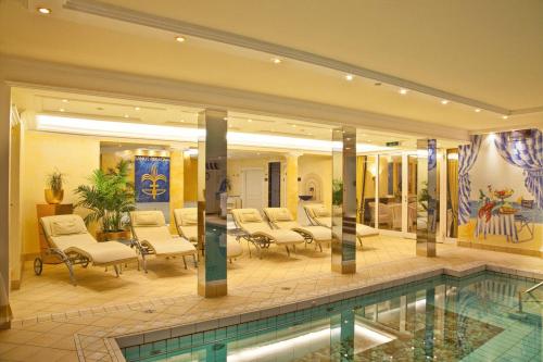 巴特沃里斯霍芬丰特奈城堡酒店的酒店大堂设有游泳池和椅子
