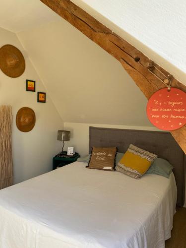 Domloup梅泰里酒店的一间卧室配有一张带白色床单和木梁的床。