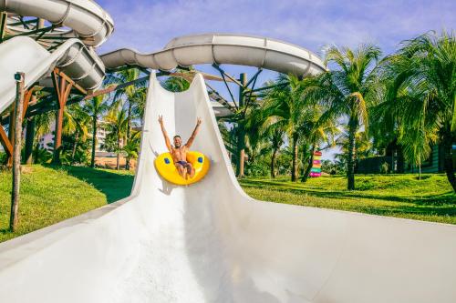 奥林匹亚Hot Beach Resort的水上公园里一个妇女乘坐滑梯