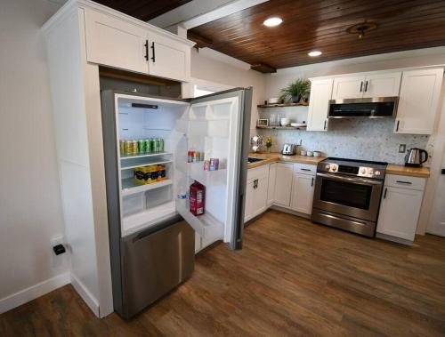 罗克雷治Shares View Luxury Apt的厨房配有白色橱柜和不锈钢冰箱