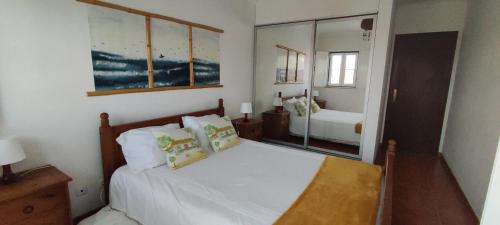 赞布热拉-杜马尔Casa com Cor的一间卧室配有一张带白色床单和镜子的床