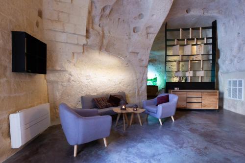 马泰拉Grotta Barisano的客厅配有沙发、两把椅子和一张桌子